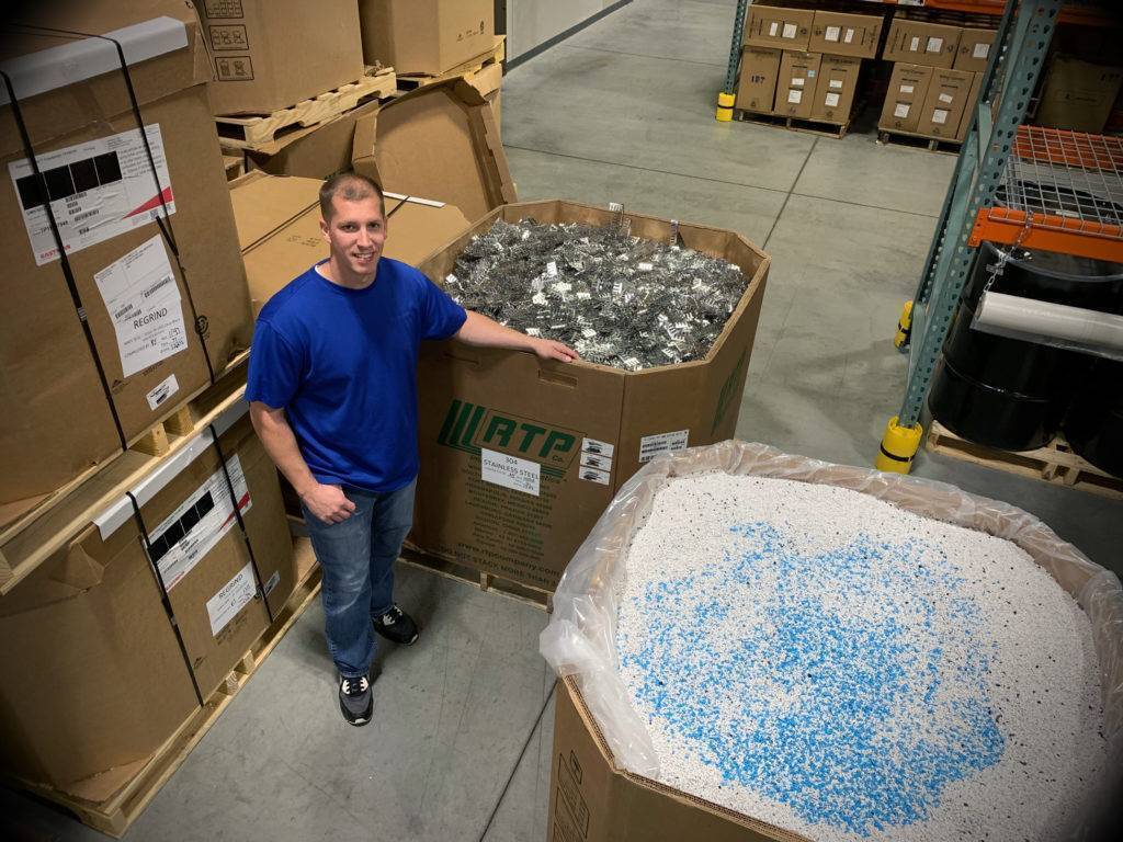 Matt Iverson of Accumold stands beside a gaylord box of resin in the Accumold warehouse